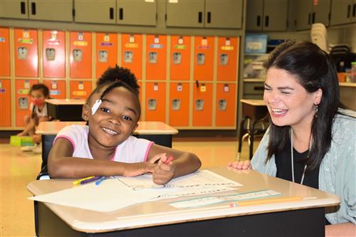 student and teacher smile over completion of a word challenge